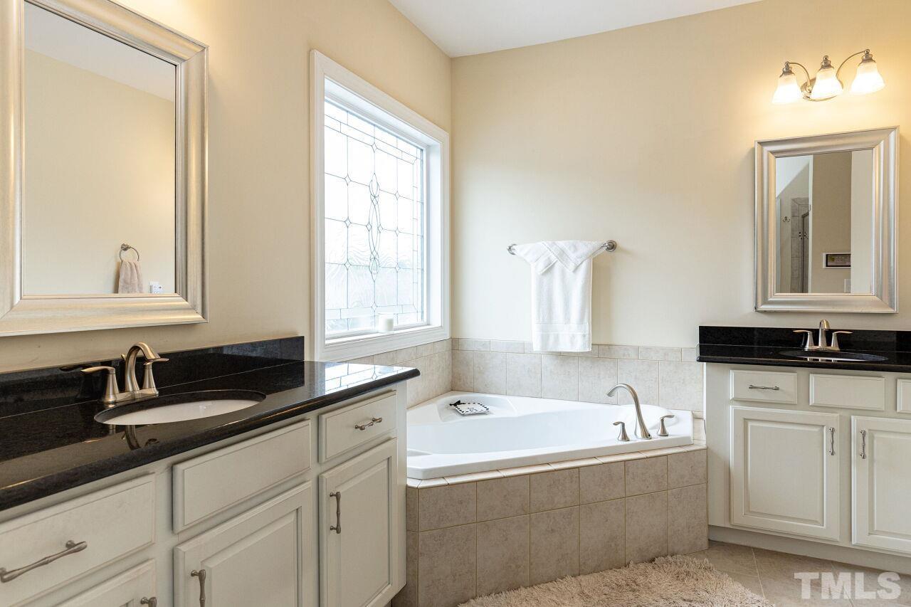 1536 Rodessa Run Raleigh, NC 27607 - Photo 22 of 53 a bathroom with a bathtub a sink a mirror and a window