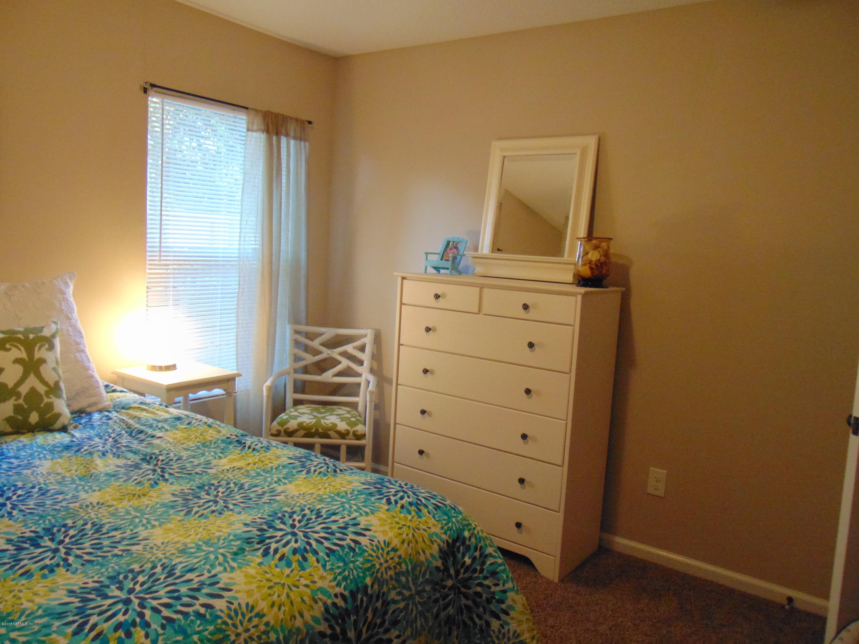 9813 Cunningham Road Jacksonville, FL 32246 - Photo 28 of 32 a bedroom with a bed and a mirror