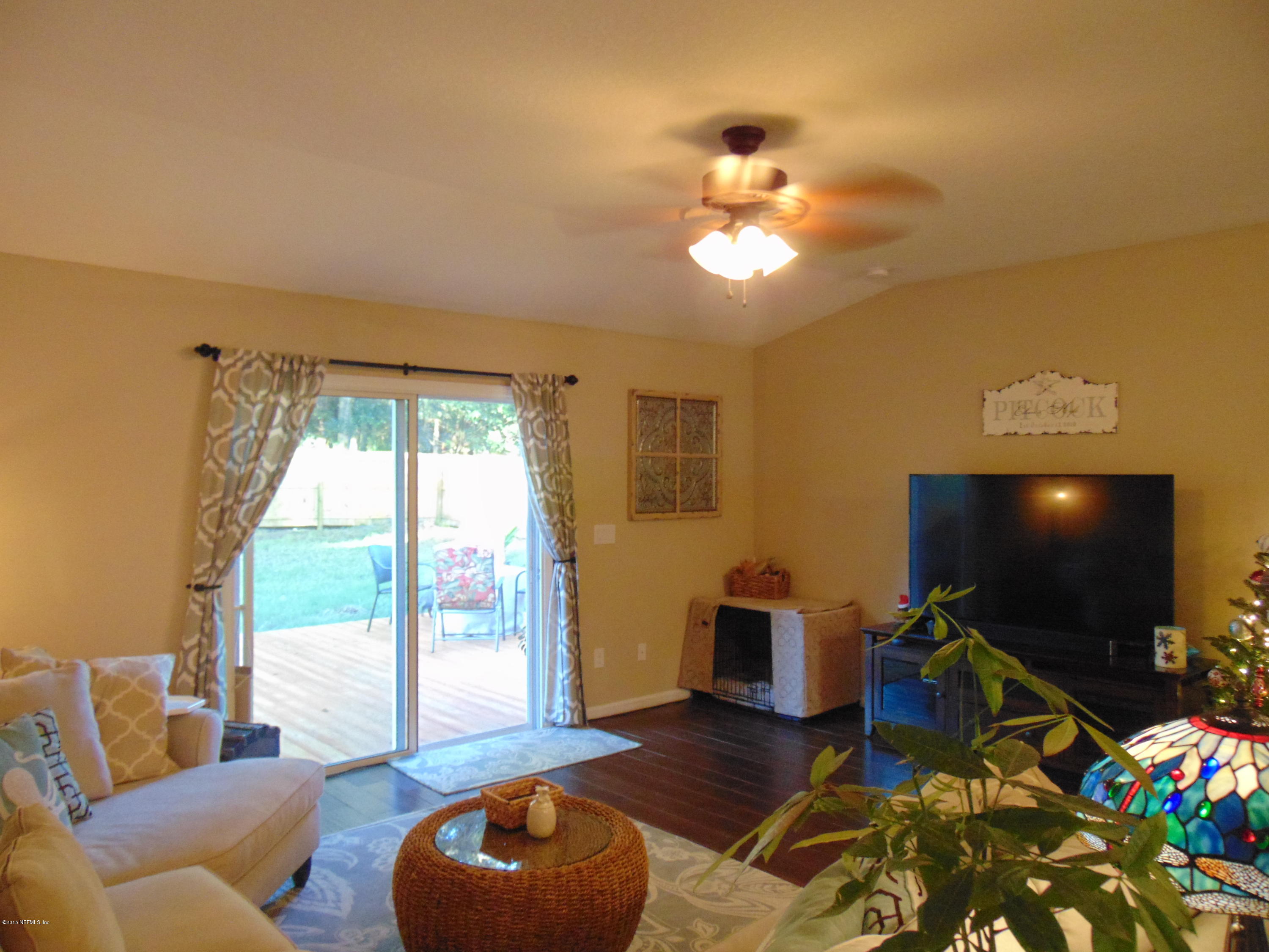 9813 Cunningham Road Jacksonville, FL 32246 - Photo 5 of 32 a living room with furniture and a flat screen tv