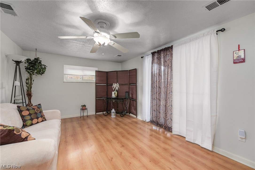 7094 Brandywine Road Parma Heights, OH 44130 - Photo 31 of 49 Living room with ceiling fan, a textured ceiling, and light hardwood / wood-style floors