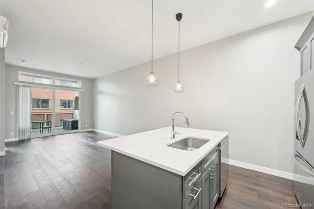 a kitchen with a sink a chandelier and wooden floor