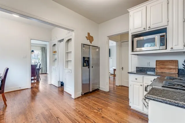 a kitchen with stainless steel appliances granite countertop a refrigerator stove and wooden floor