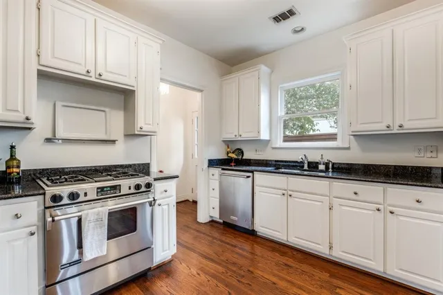a kitchen with granite countertop white cabinets and white appliances