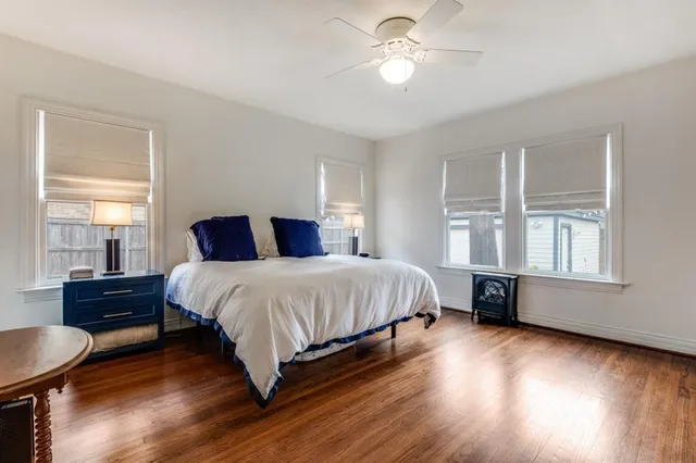 a bedroom with a large bed and wooden floor