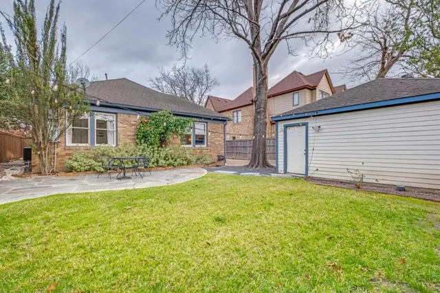 a view of a house with a yard and potted plants