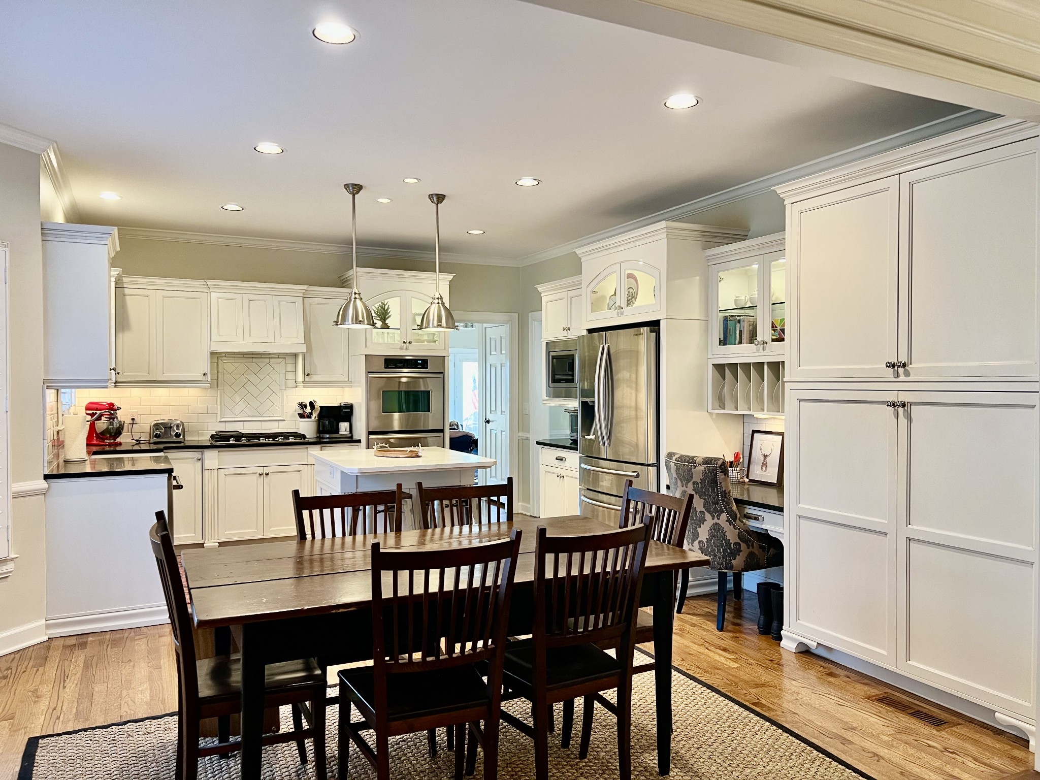 4264 Warren Road Franklin, TN 37067 - Photo 7 of 49 a kitchen with kitchen island granite countertop a dining table chairs and white cabinets