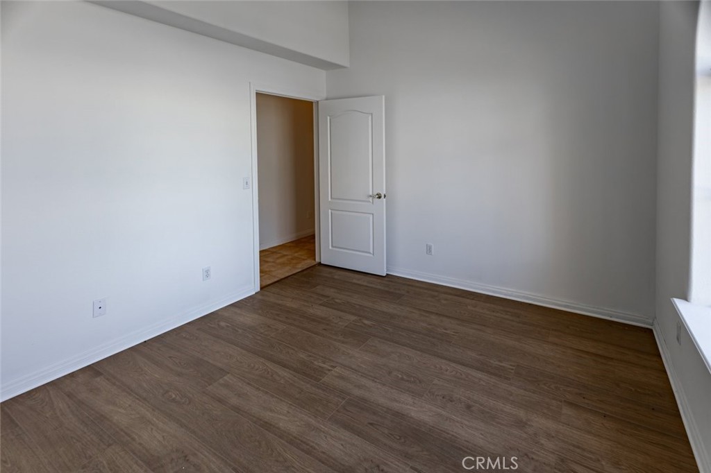12384 Redwood Road Pinon Hills, CA 92372 - Photo 21 of 35 a view of an empty room with wooden floor and a window