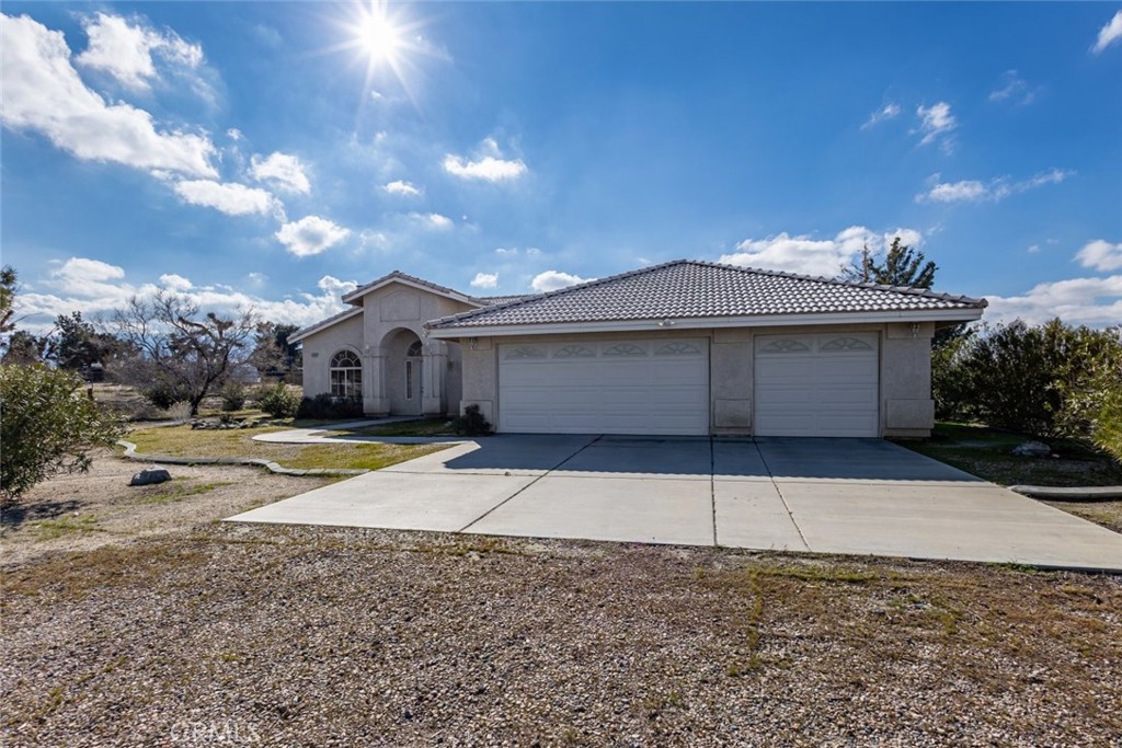 12384 Redwood Road Pinon Hills, CA 92372 - Photo 32 of 35 a front view of a house with a yard and garage
