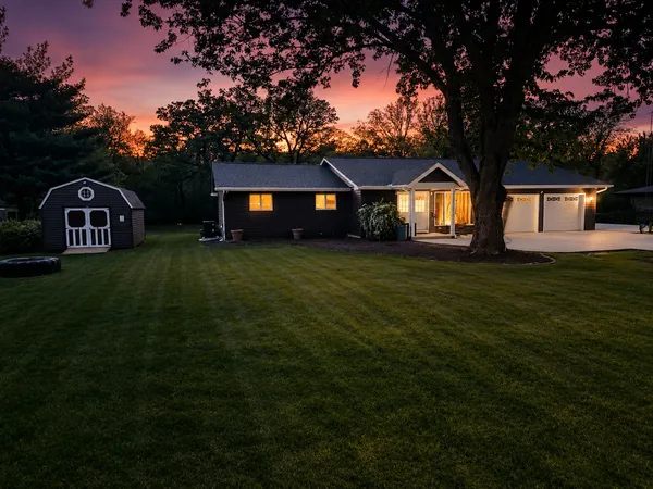 a view of a yard in front of a house with large trees