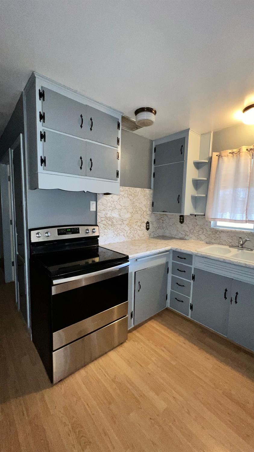56 West Hanford Armona Road Lemoore, CA 93245 - Photo 13 of 15 a kitchen with a stove and a sink
