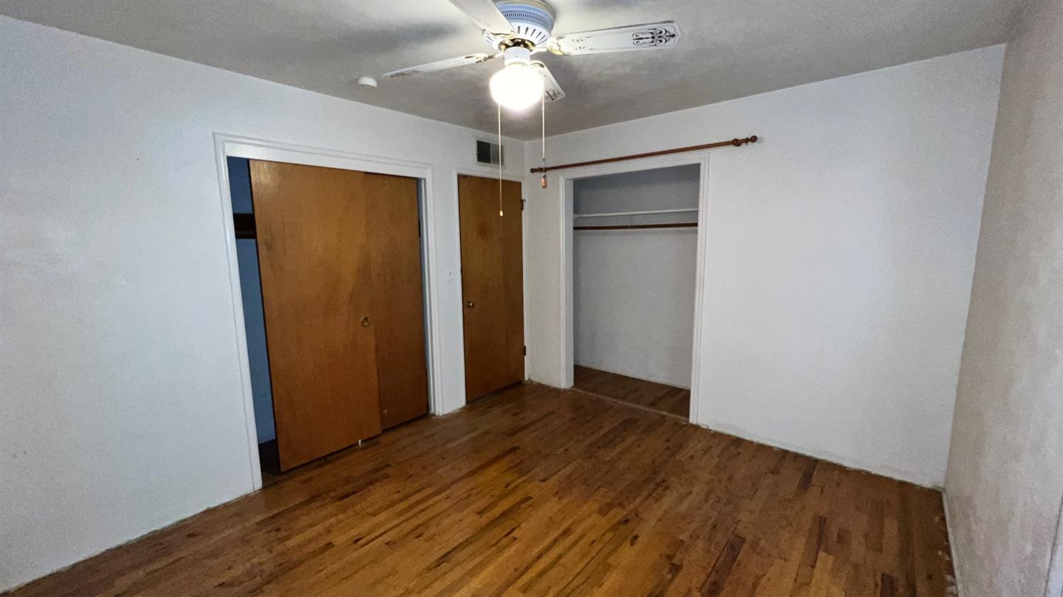 56 West Hanford Armona Road Lemoore, CA 93245 - Photo 3 of 15 a view of an empty room with wooden floor and a ceiling fan