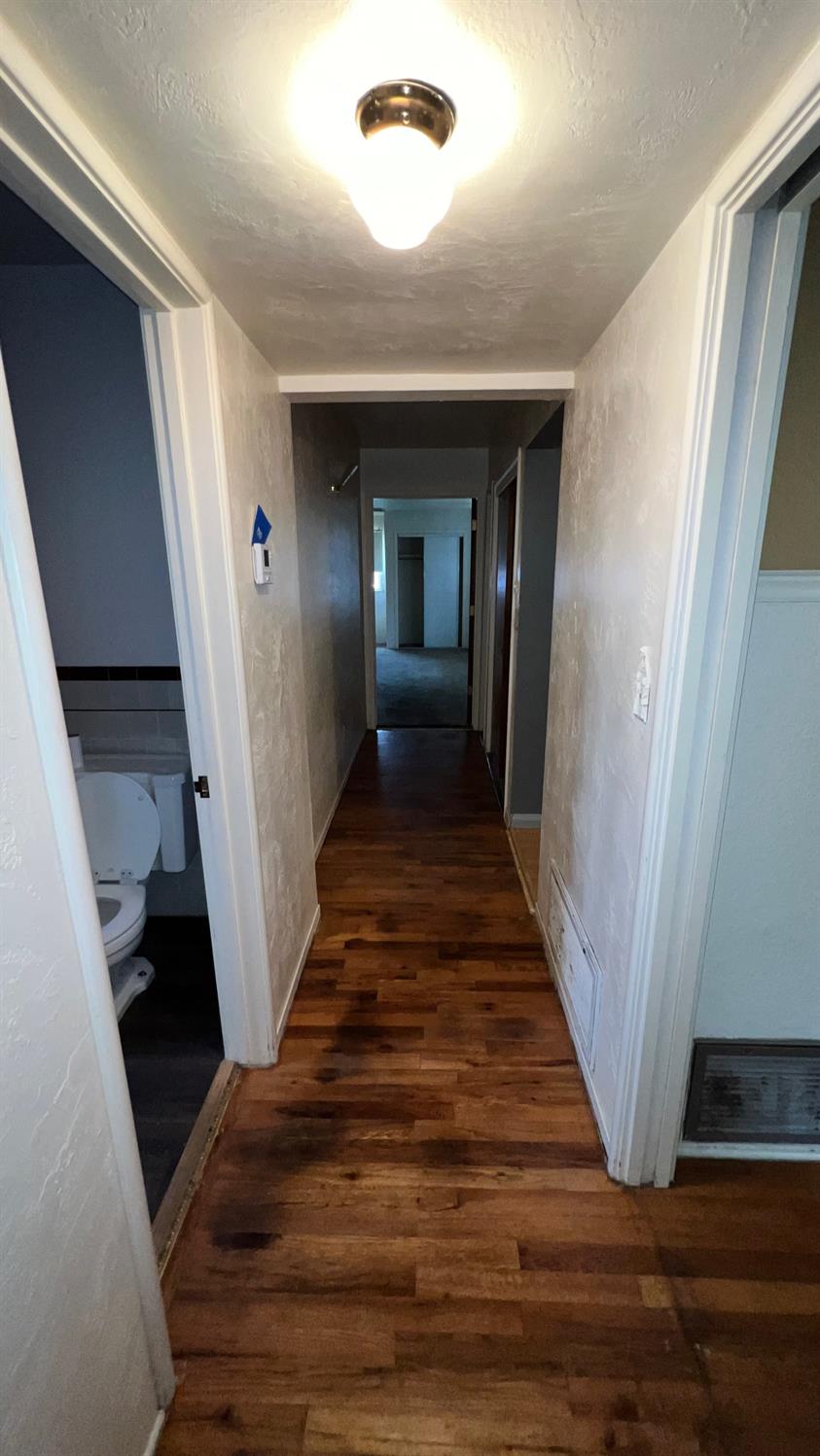 56 West Hanford Armona Road Lemoore, CA 93245 - Photo 6 of 15 a view of a hallway with wooden floor and staircase
