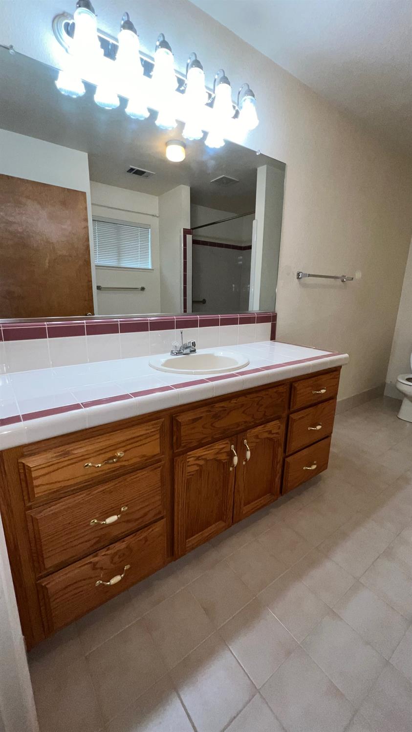 56 West Hanford Armona Road Lemoore, CA 93245 - Photo 10 of 15 a spacious bathroom with a double vanity sink and a mirror