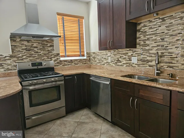a kitchen with granite countertop cabinets a sink and stainless steel appliances