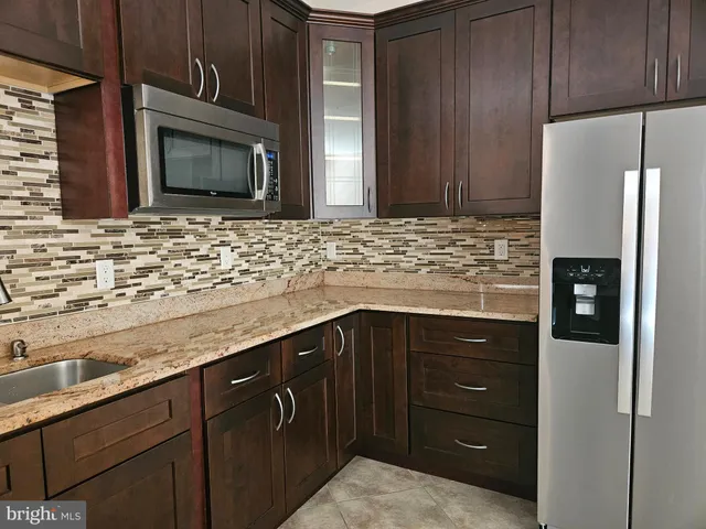 a kitchen with granite countertop stainless steel appliances and refrigerator