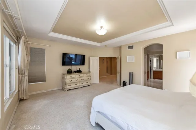 a spacious bedroom with a bed and a large window