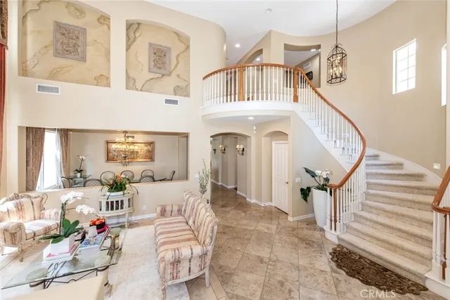 a living room with furniture a fireplace and a chandelier