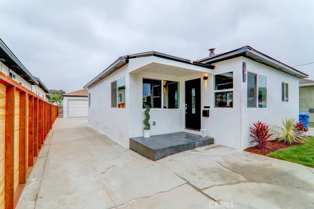 a view of a house with a yard and potted plants