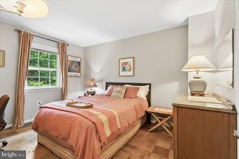 a bedroom with a bed and a lamp on dresser