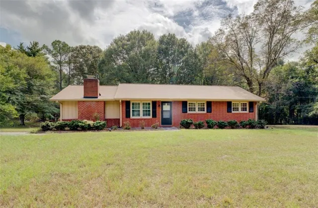 a view of a house with a yard and sitting area