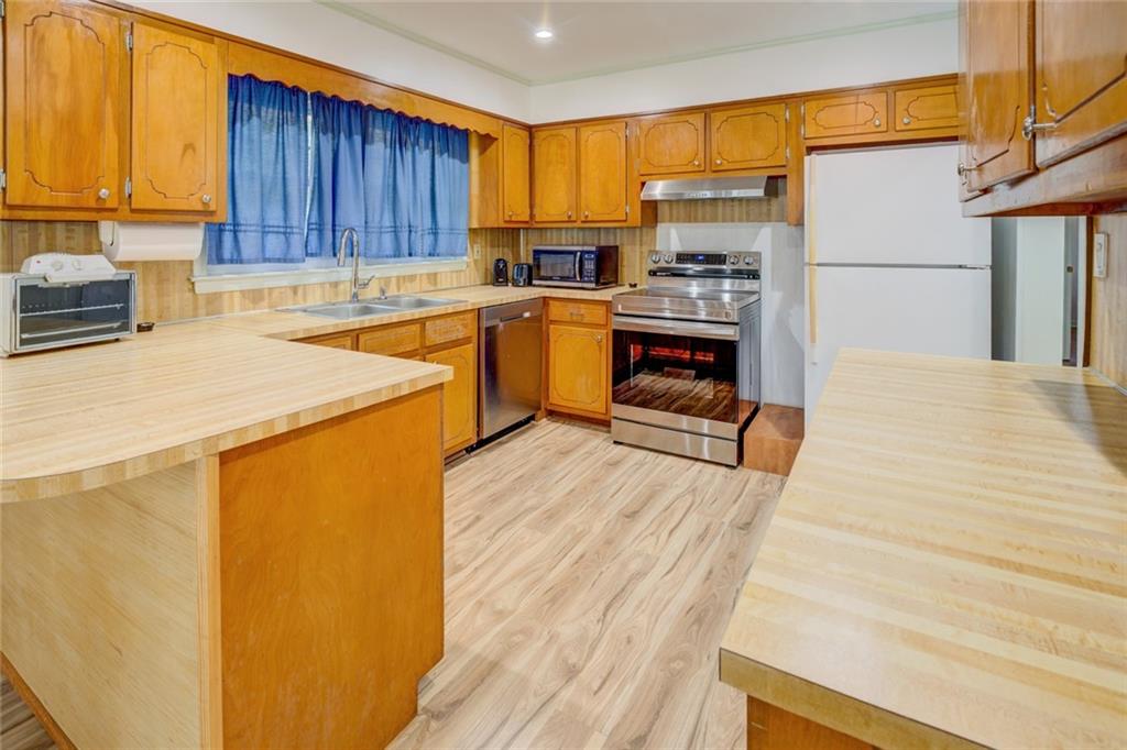 2194 Klondike Road Southwest Conyers, GA 30094 - Photo 11 of 30 a kitchen with wooden cabinets and a stainless steel appliances