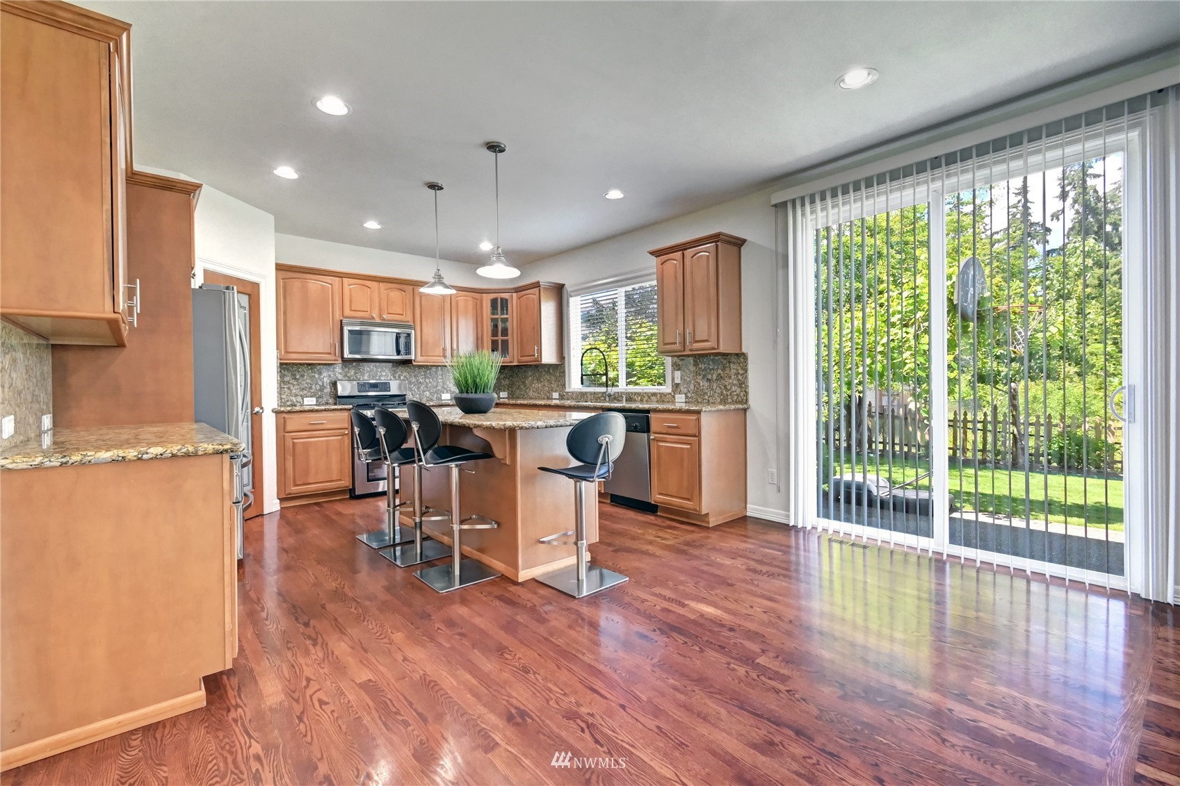 914 Southwest 361st Street Federal Way, WA 98023 - Photo 14 of 40 a kitchen with stainless steel appliances granite countertop wooden floor a refrigerator cabinets and a dining table