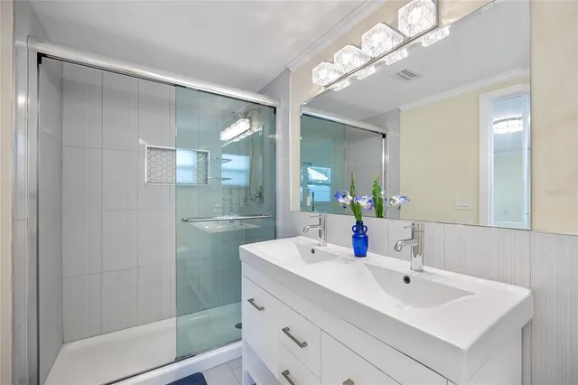 a bathroom with a sink shower and a mirror