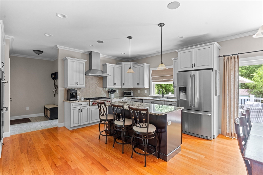 5 Clinton Drive Rehoboth, MA 02769 - Photo 4 of 37 a kitchen with stainless steel appliances granite countertop a stove a refrigerator a sink a dining table and chairs with wooden floor