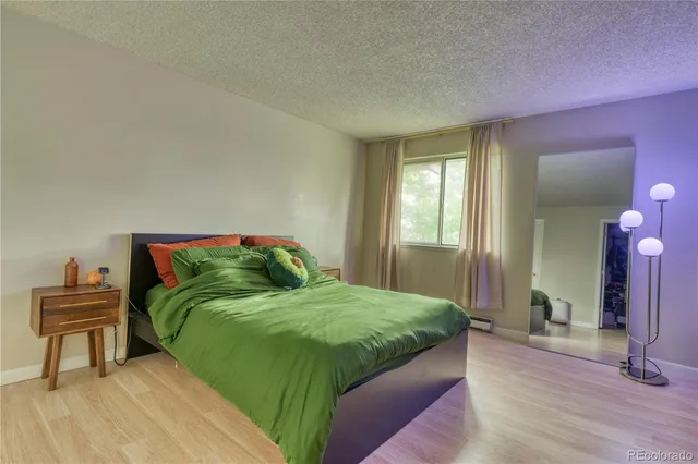 a bedroom with a bed and a painting on the wall