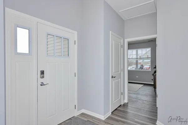 a view of a hallway with wooden floor and a bathroom