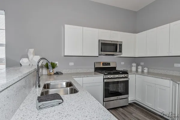 a kitchen with cabinets a sink and a potted plant
