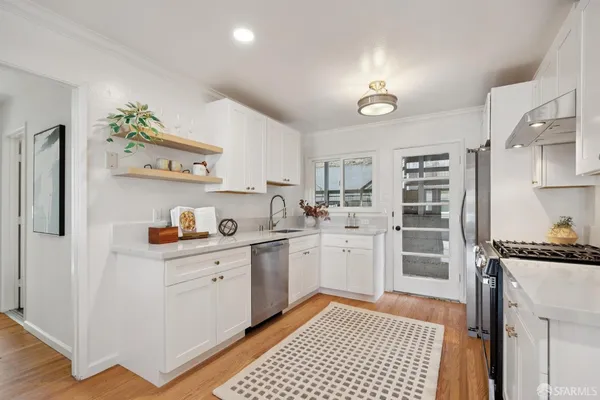 a kitchen with white cabinets sink and stove