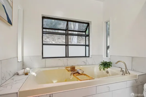 a bathroom with a granite countertop toilet sink and mirror