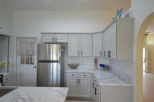 a kitchen with stainless steel appliances granite countertop a sink a stove and a refrigerator
