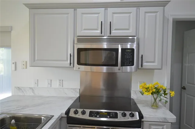 a kitchen with stainless steel appliances granite countertop a refrigerator and a stove top oven