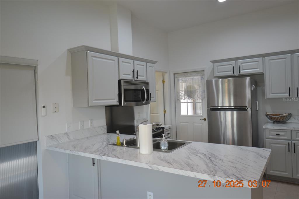 4020 Casa Del Sol Way New Port Richey, FL 34655 - Photo 86 of 98 a kitchen with stainless steel appliances granite countertop a refrigerator a stove and a sink