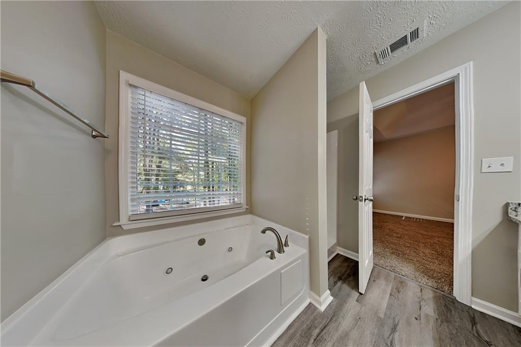 204 Leighs Grove Court Grayson, GA 30017 - Photo 13 of 23 a bathroom with a bathtub and a shower