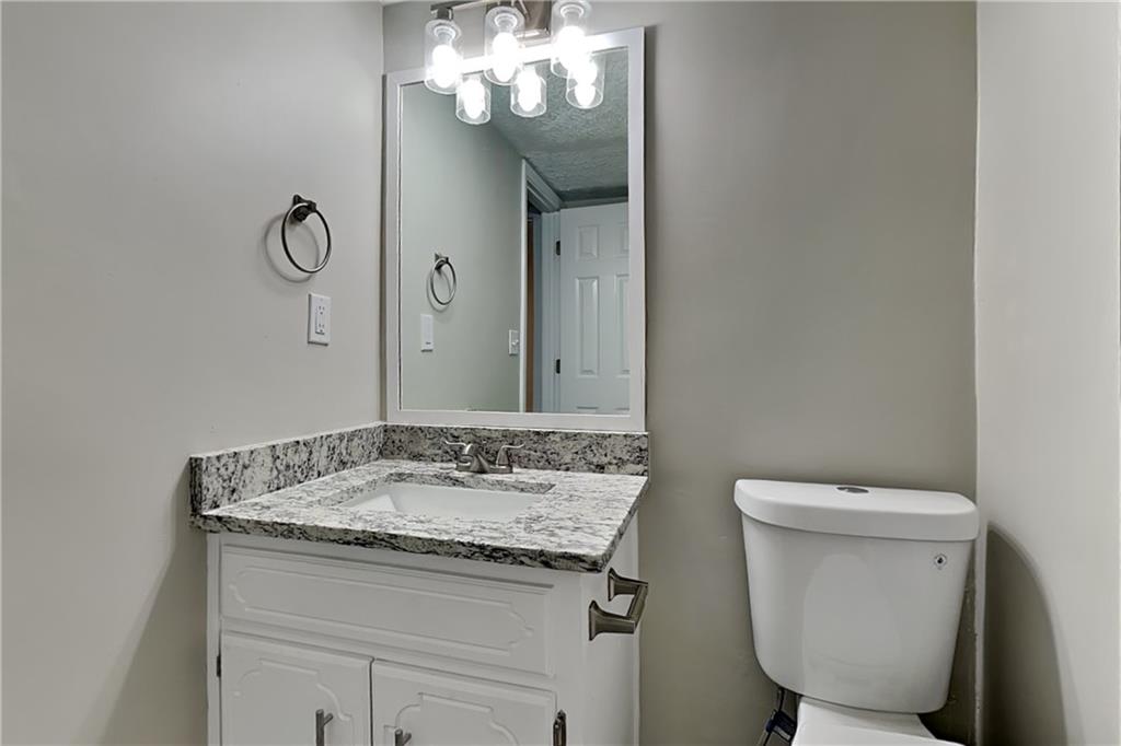 204 Leighs Grove Court Grayson, GA 30017 - Photo 19 of 23 a bathroom with a granite countertop sink a toilet and a mirror