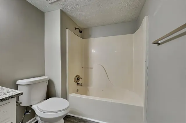 a white toilet sitting next to a bath tub