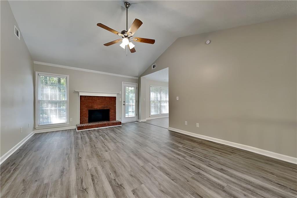 204 Leighs Grove Court Grayson, GA 30017 - Photo 2 of 23 an empty room with wooden floor fireplace and windows