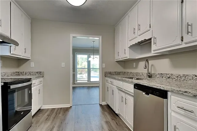 a kitchen with stainless steel appliances granite countertop a stove a sink and a refrigerator