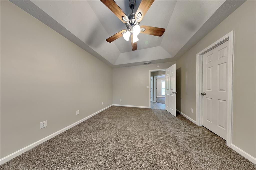 204 Leighs Grove Court Grayson, GA 30017 - Photo 10 of 23 an empty room with chandelier fan and windows