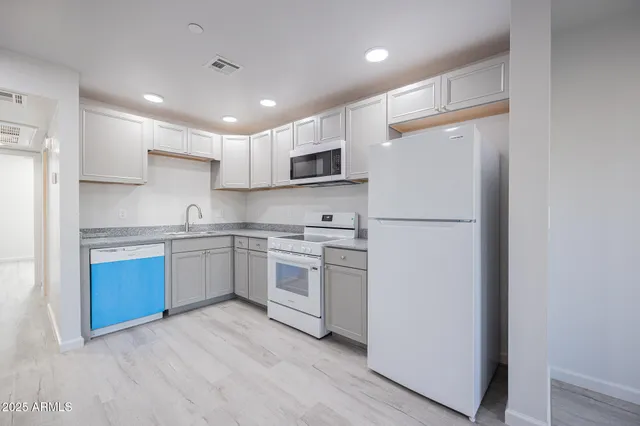 a kitchen with white cabinets and stainless steel appliances