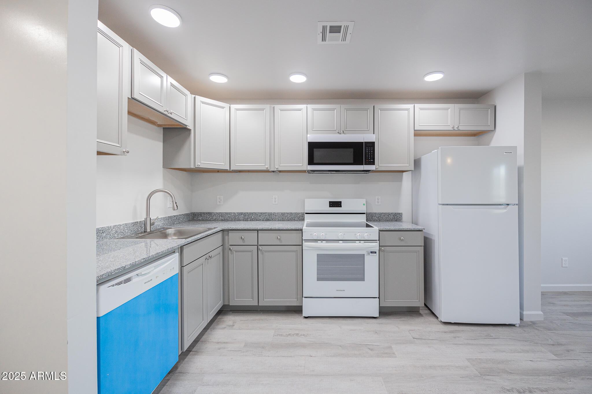 2121 West Adams Street, Unit B102 Phoenix, AZ 85009 - Photo 13 of 25 a kitchen with white cabinets and stainless steel appliances
