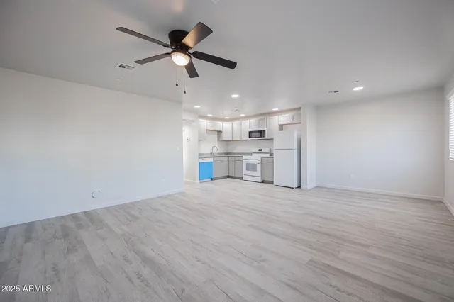 a view of a kitchen with a sink stove refrigerator and cabinets