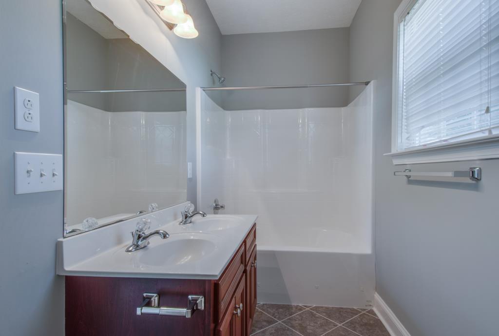 583 Neelys Bend Road Madison, TN 37115 - Photo 14 of 23 The master bathroom features double vanities and a really nice closet with lovely built in storage shelves.