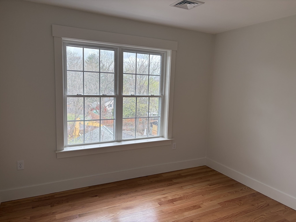 76 Valmor Street Worcester, MA 01604 - Photo 15 of 20 an empty room with wooden floor and windows