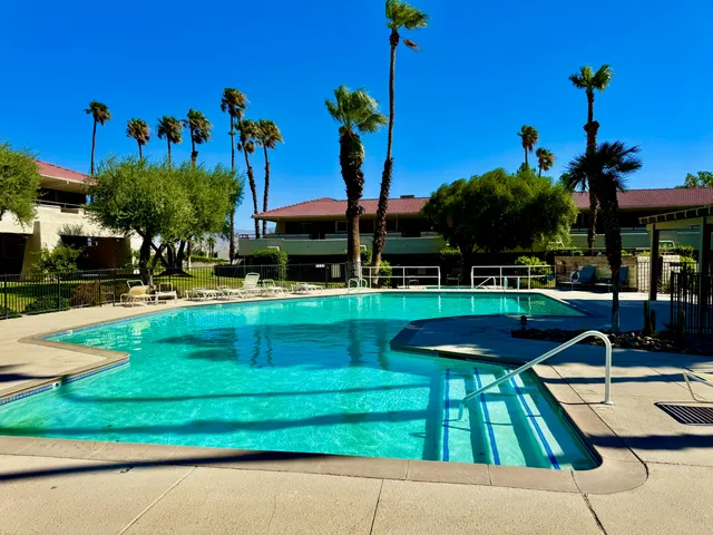 a view of a swimming pool with a garden and patio