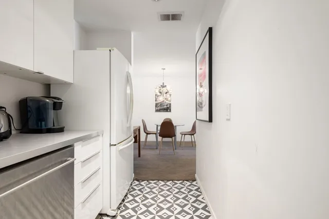 a view of a hallway and a dining room with table and chairs
