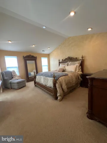 a spacious bedroom with a bed couch and a window